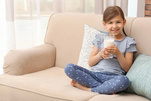 Χαριτωμένο Μικρό Κορίτσι Ποτήρι Γάλα Στον Καναπέ Στο Σπίτι — Φωτογραφία Αρχείου