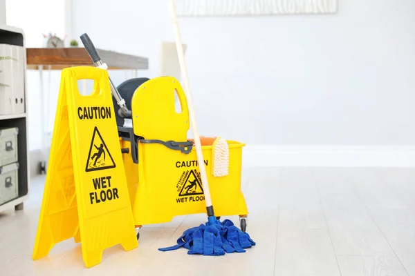 警告湿地板 在安全标志和拖把桶与清洁用品 — 图库照片