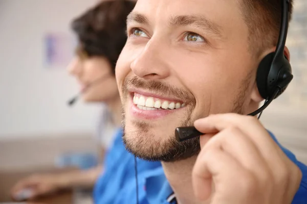 Male technical support operator with headset at workplace