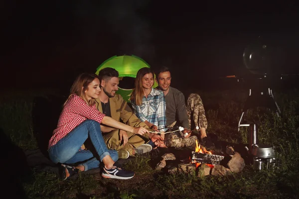 Arkadaşlar gece şenlik ateşi üzerinde Marshmallows kızartma. Kamp sezon
