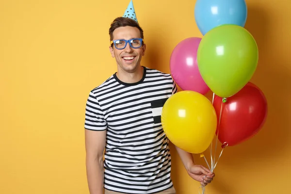 Jonge Man Met Heldere Ballonnen Achtergrond Kleur Verjaardagsviering — Stockfoto