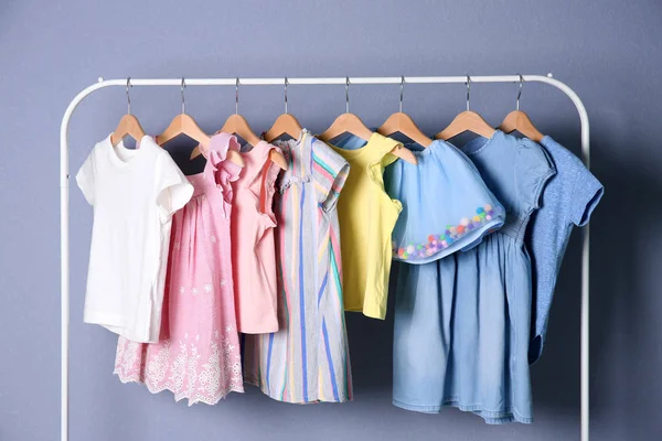 Renk Arka Plan Üzerinde Şık Çocuk Giysileri Ile Raf — Stok fotoğraf