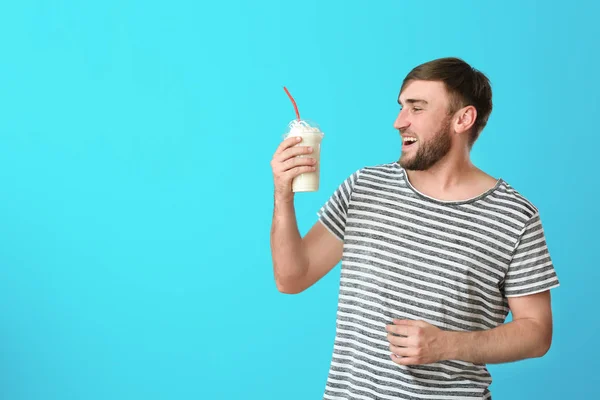 Ung Man Med Kopp Läcker Milkshake Färgbakgrund — Stockfoto