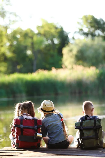 Ahşap iskele üzerinde oturan çocuk. Yaz Kampı
