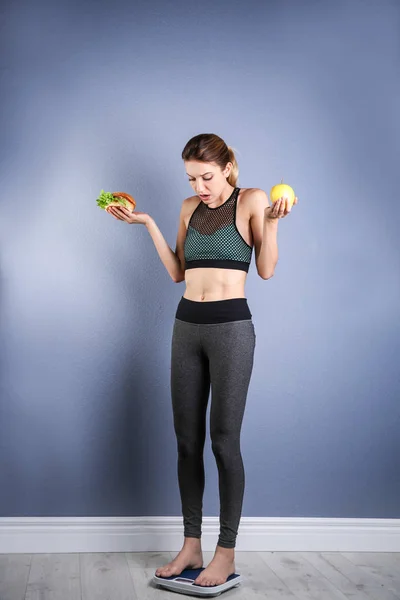 Mujer Sosteniendo Sabroso Sándwich Manzana Mientras Mide Peso Escalas Suelo —  Fotos de Stock