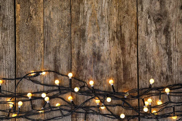 Leuchtende Weihnachtsbeleuchtung Auf Hölzernem Hintergrund Draufsicht — Stockfoto