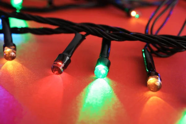 Leuchtende Weihnachtsbeleuchtung Auf Farbigem Hintergrund Nahaufnahme — Stockfoto