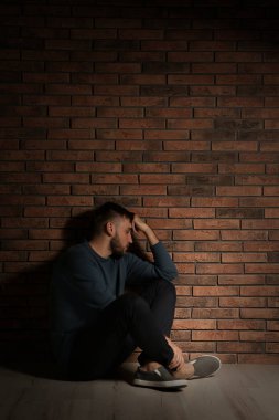 Duvara yakın katta oturan depresif genç adam