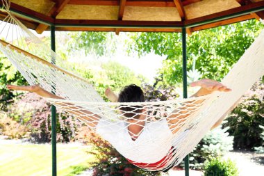 Adam açık havada sıcak yaz gününde hamakta rahatlatıcı