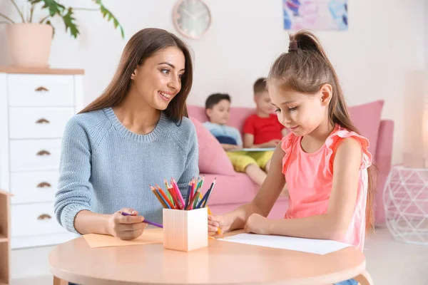 Lindo Niño Pequeño Dibujo Mesa Con Mujer Joven Sala Juegos —  Fotos de Stock