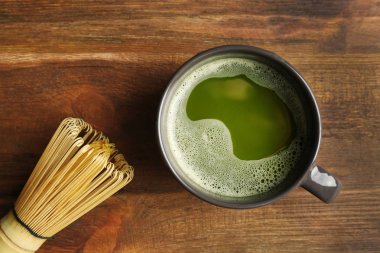 Fincan taze matcha çay ve chasen ahşap arka plan, üstten görünüm