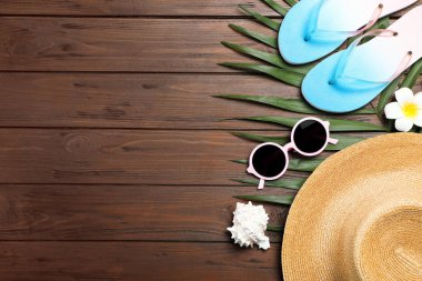 Tahta zemin üzerinde plaj nesneleri ile düz kompozisyon yatıyordu