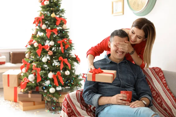 自宅のクリスマス プレゼントで彼氏を意外な若い女性 — ストック写真