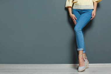 Seksi bacaklar gri duvarının yakınında olan kadın