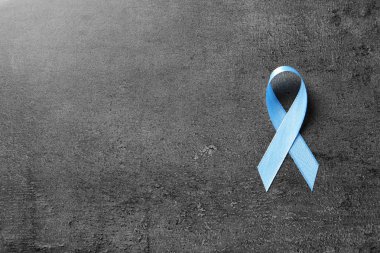 Gri arka plan, üstten görünüm olarak blue ribbon. Kanseri bilinçlendirme
