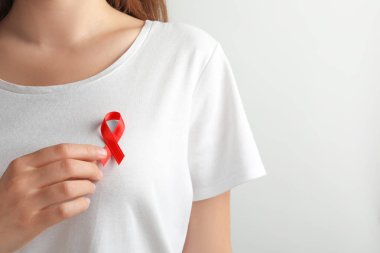 Kırmızı kurdele t-shirt üzerinde açık renkli karşı olan kadın. Kanseri bilinçlendirme
