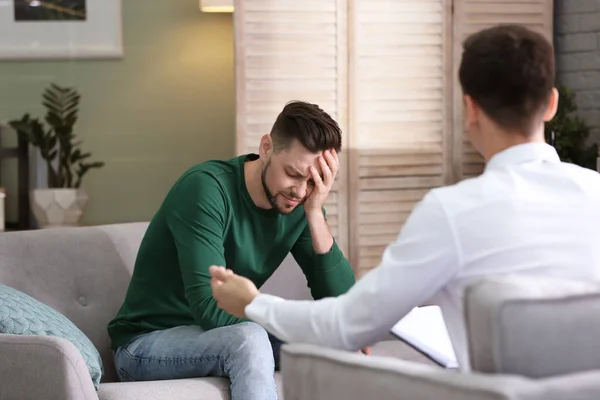 Male psychologist with client in office