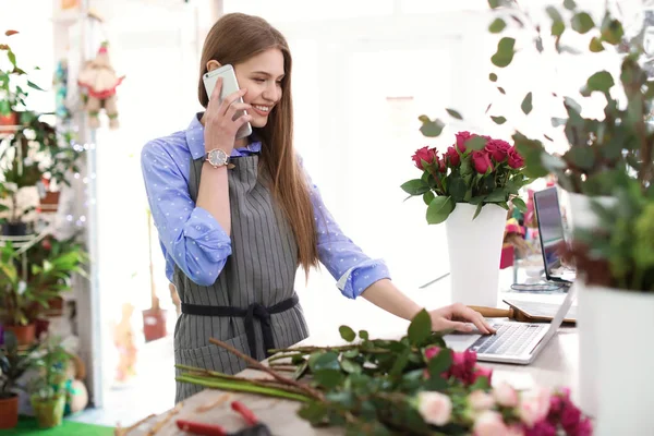 Молодой Флорист Работает Ноутбуком Разговаривает Мобильному Телефону Цветочном Магазине — стоковое фото