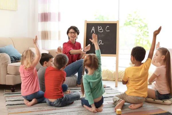 Jovem Mulher Ensinando Crianças Pequenas Dentro Casa Aprendendo Jogando — Fotografia de Stock