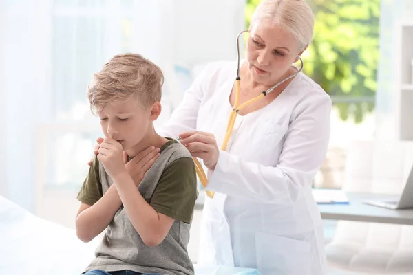 医師のクリニックで小さな男の子を咳を調べる — ストック写真