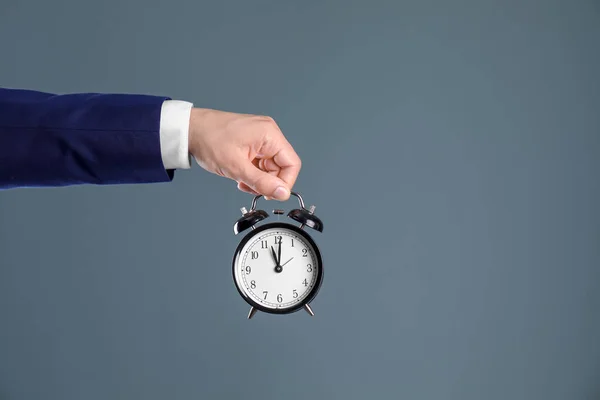 Joven Hombre Negocios Sosteniendo Reloj Sobre Fondo Color Gestión Del —  Fotos de Stock