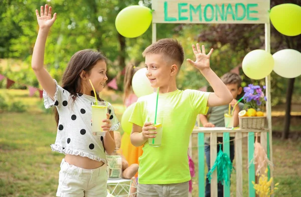 公園で天然レモネードを飲む小さな子供たち — ストック写真