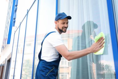 Erkek işçi pencereyi dışarıdan yıkıyor.
