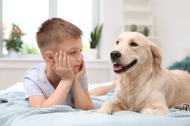 Yatakta evde onun Evcil hayvan ile şirin küçük çocuk