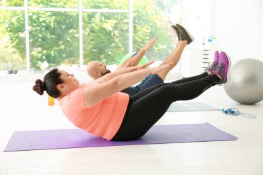 Erkek ve kadın üzerinde paspas spor salonunda egzersiz yaparak kilolu