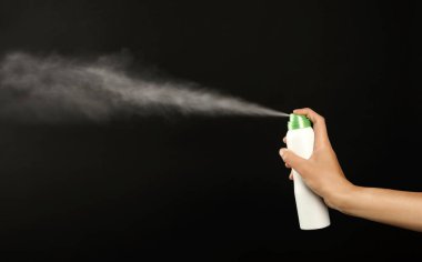 Genç kadın deodorant siyah arka plan üzerine püskürtme