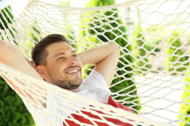 Adam açık havada sıcak yaz gününde hamakta rahatlatıcı