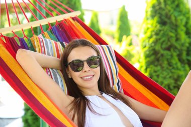 Genç kadın açık havada sıcak yaz gününde hamakta rahatlatıcı