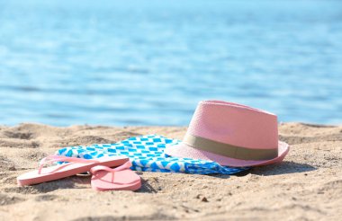 Parlak havlu, şapka ve kum deniz kenarında üzerinde flip flop. Beach nesne