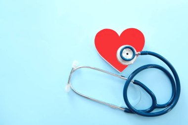 Kırmızı kalp ve stetoskop renk arka plan, üstten görünüm üzerinde düz yatıyordu kompozisyonu