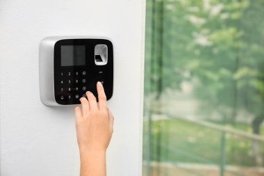Genç kadın kapalı alarm sistemi tuş takımında kodunu girme