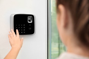 Genç kadın kapalı alarm sistemi tuş takımında kodunu girme