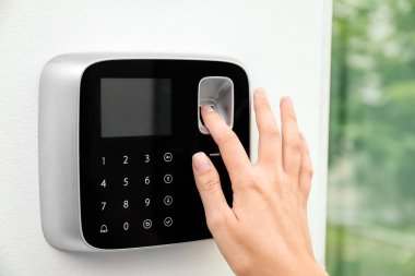 Genç kadın alarm sistemi kapalı üzerinde parmak izi tarama