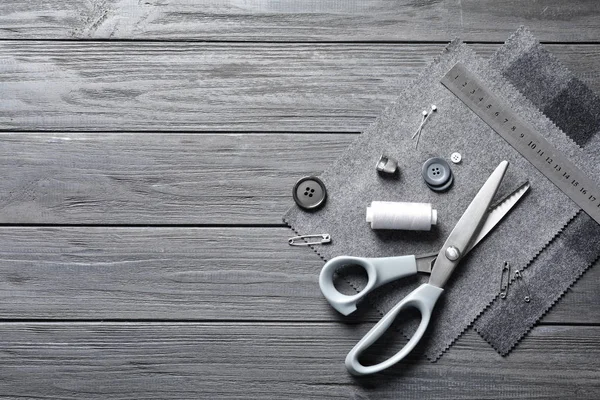 Aksesuar ve kumaş ahşap arka planda, yukarıdan dikiş seti