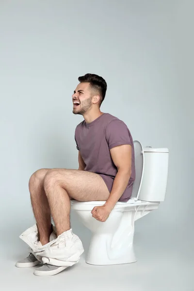 Jeune Homme Souffrant Diarrhée Sur Cuvette Toilette Sur Fond Gris — Photo