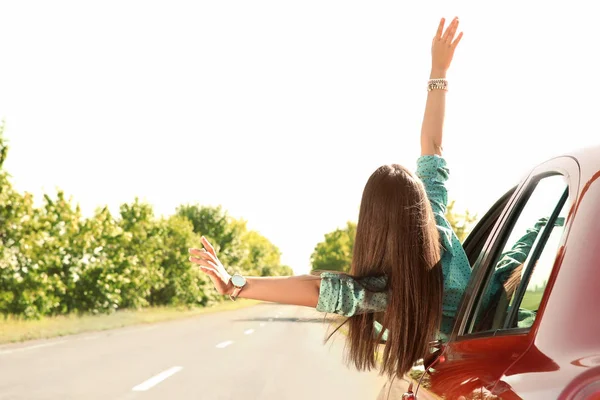 genç bir kadın araba penceresinden yaslanmış