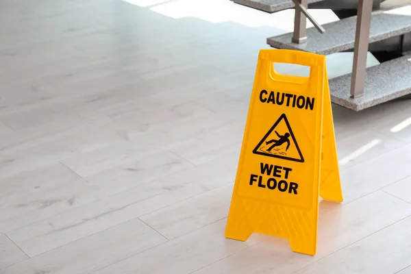 Safety sign with phrase Caution wet floor near stairs. Cleaning service