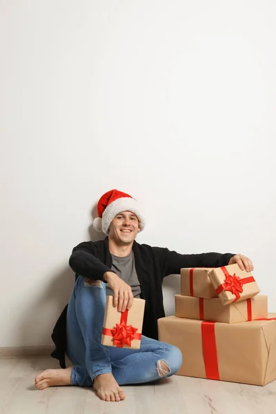 Молодой Человек Рождественскими Подарками Возле Белой Стены — стоковое фото