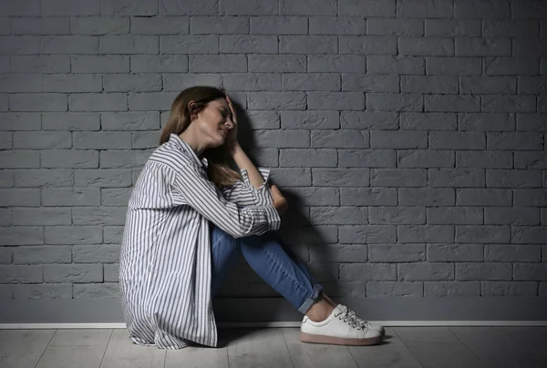レンガの壁近くうつ病で苦しんで孤独な女性 — ストック写真