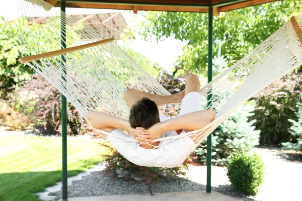 Adam açık havada sıcak yaz gününde hamakta rahatlatıcı