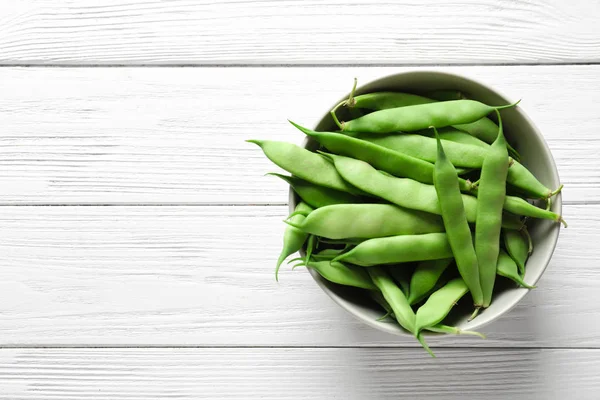 Ahşap masa, üstten görünüm taze yeşil fasulye ile kase