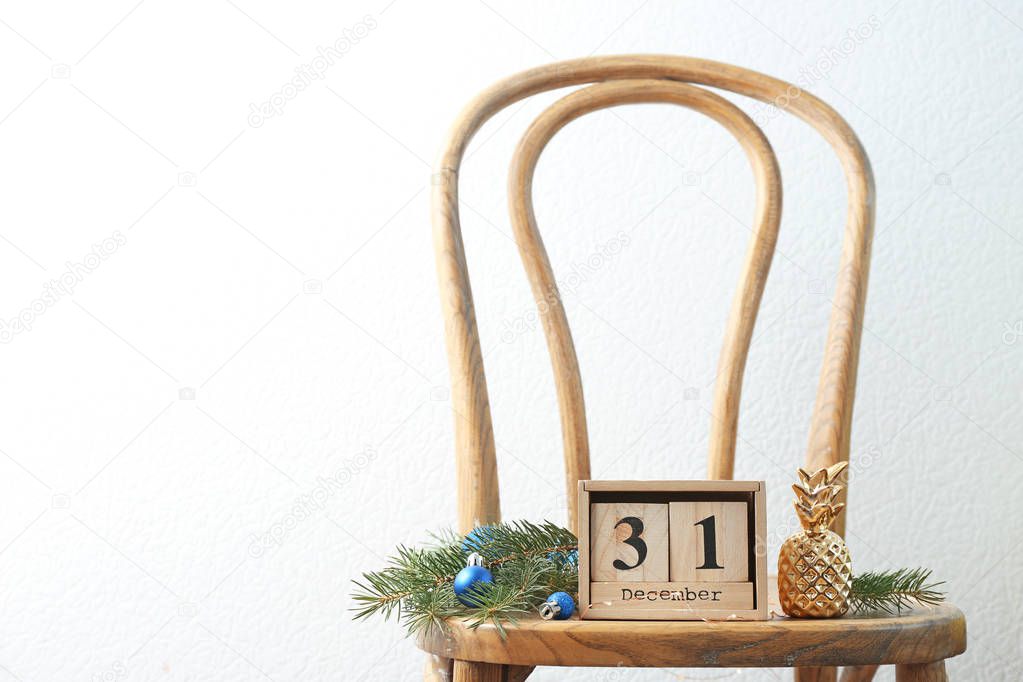 Wooden block calendar and festive decor on chair. Christmas countdown