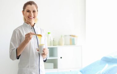 Salonda epilasyonda balmumu ile kadın güzellik uzmanı