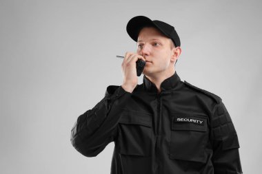 Erkek güvenlik görevlisi taşınabilir radyo vericisi renk arka plan üzerinde kullanma