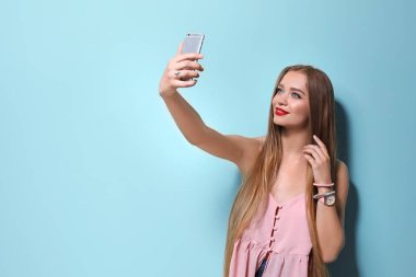 Selfie renk arka plan üzerinde alarak çekici genç kadın