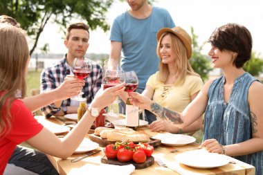 Bardak şarap masada açık havada Genç insanlarla. Yaz Barbekü